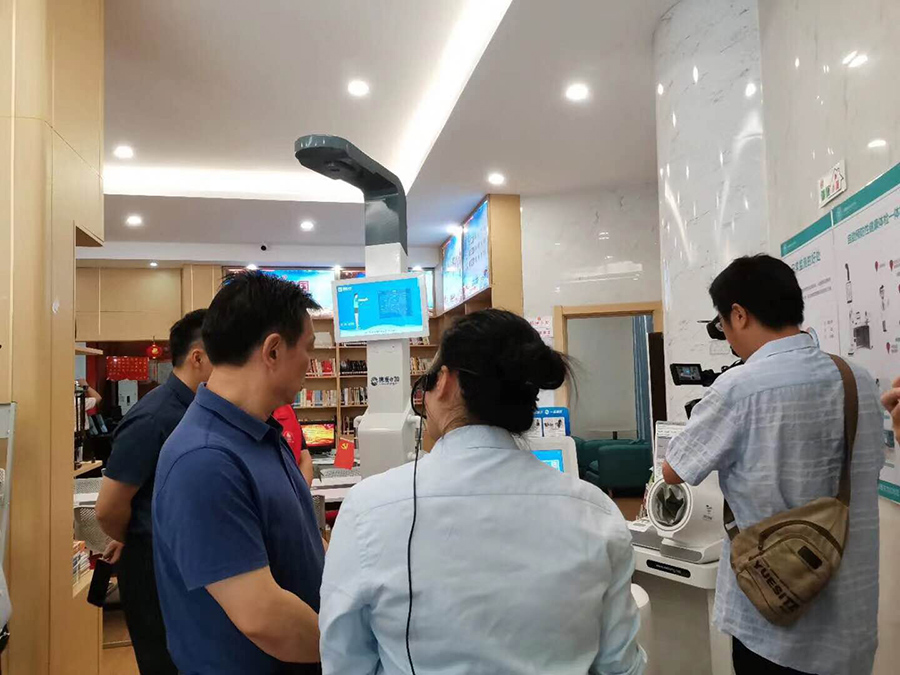 南昌市領(lǐng)導(dǎo)蒞臨東方紅社區(qū)鄰里中心“攜康·健康小屋”考察工作 工作人員正在為領(lǐng)導(dǎo)介紹攜康·健康管理一體機(jī)(XKZN-B600型)的功能和使用情況