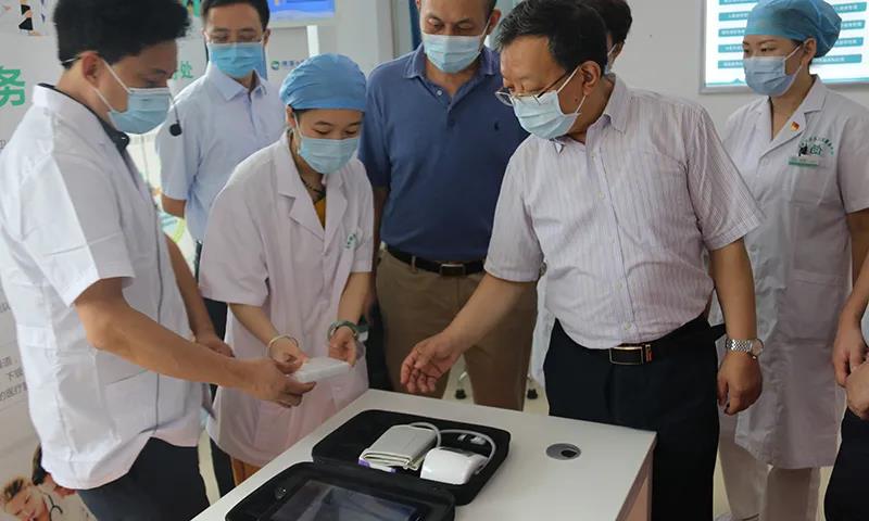 左嶺街社區(qū)衛(wèi)生服務(wù)中心院長張劍為聶春雷等調(diào)研人員介紹攜康·智能健康服務(wù)包在基層衛(wèi)生服務(wù)中的實際應(yīng)用