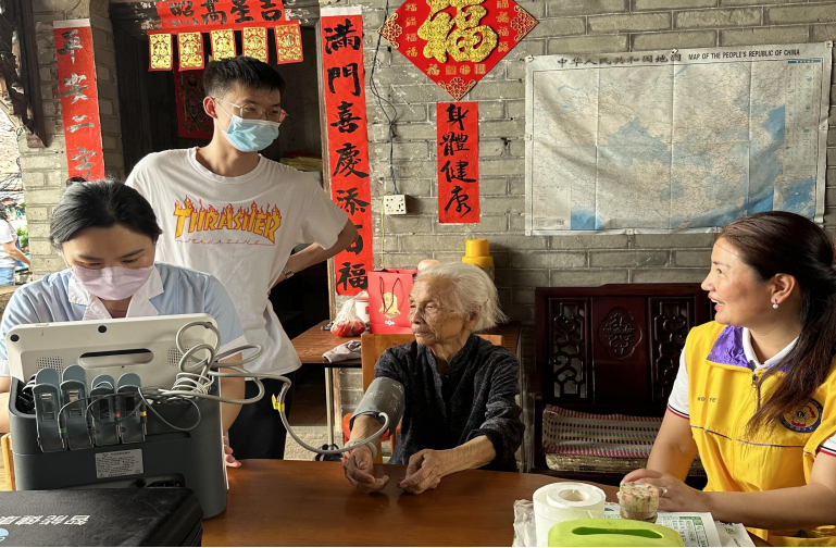 攜康工作人員提著智慧診療簽約一體機(jī)前往老人家中進(jìn)行免費(fèi)健康服務(wù)